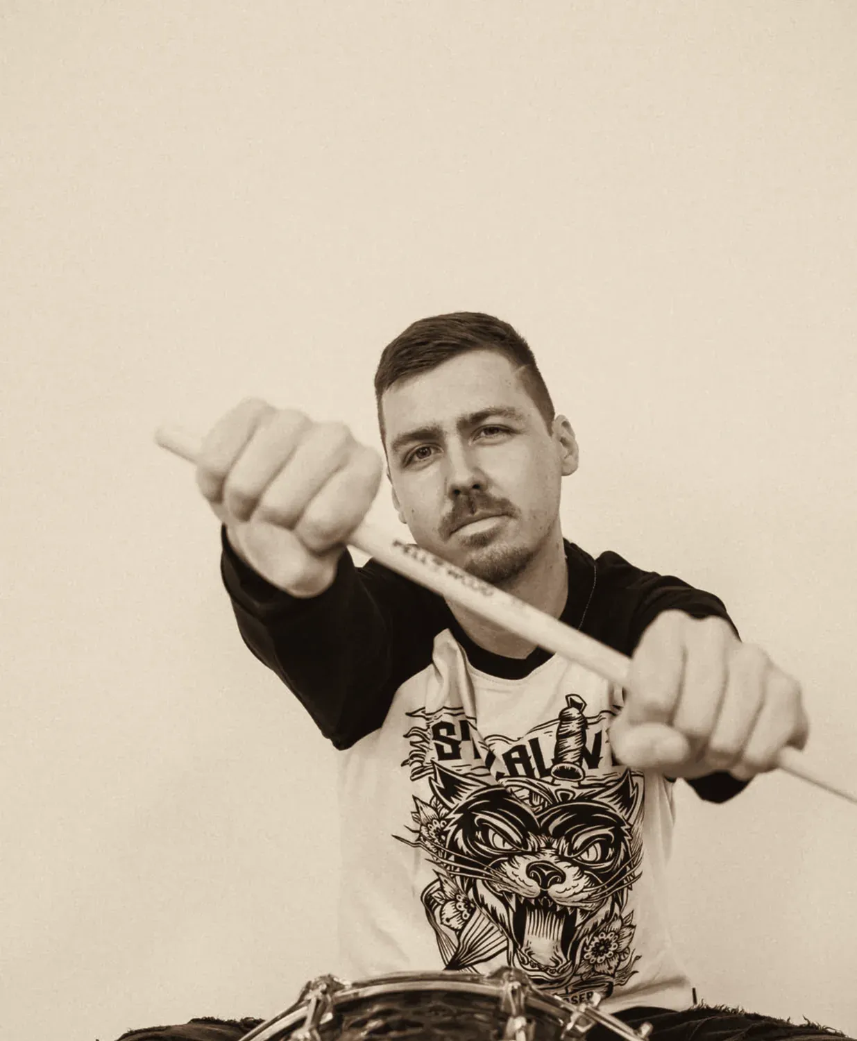 Patrik Árendás míří bubenickými paličkami do objektivu